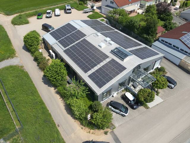 Foto eines Firmengebäudes von oben mit PV-Paneelen auf dem Dach
